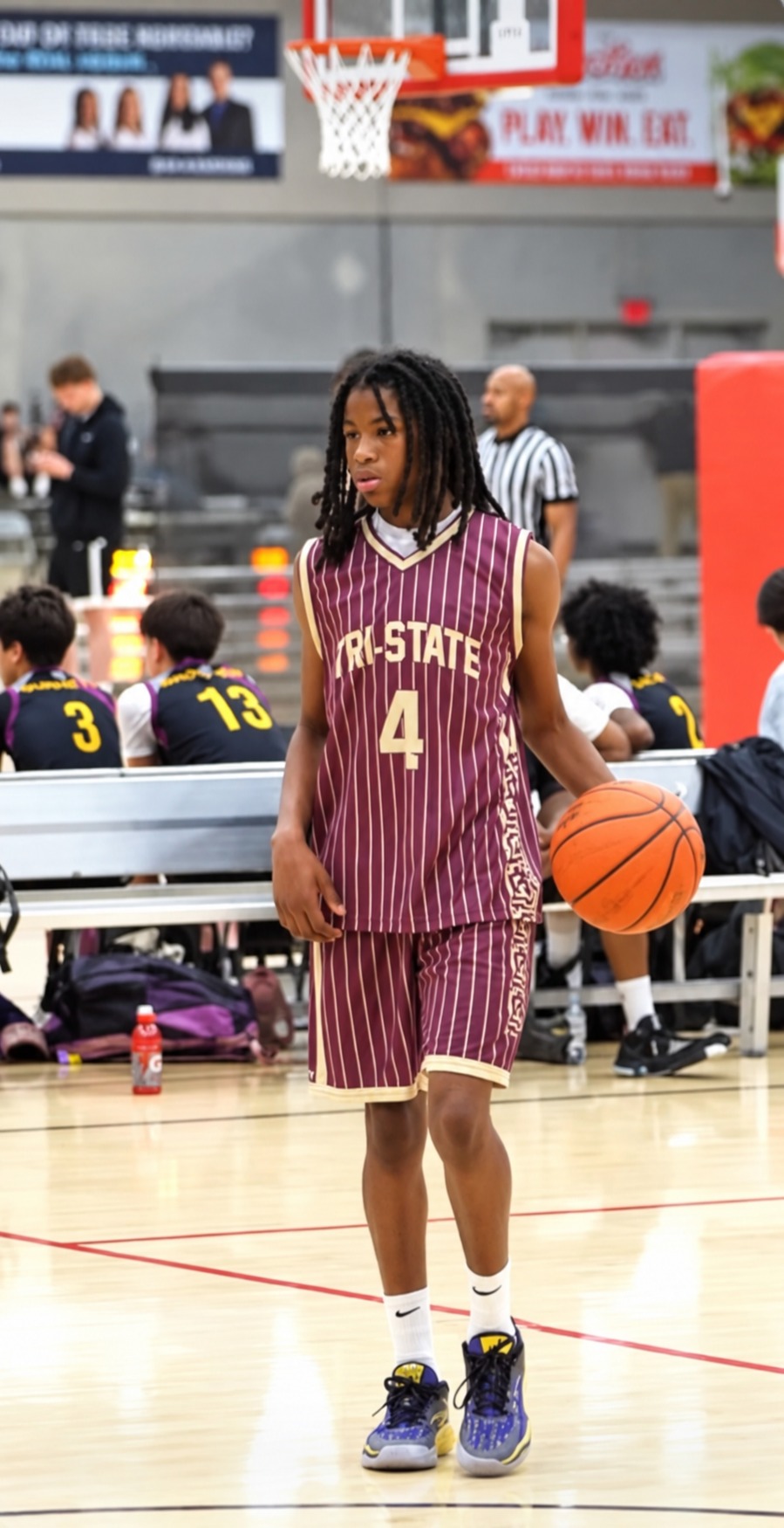 KJ Townsend in a maroon number 4 Tri-State basketball uniform holding a basketball